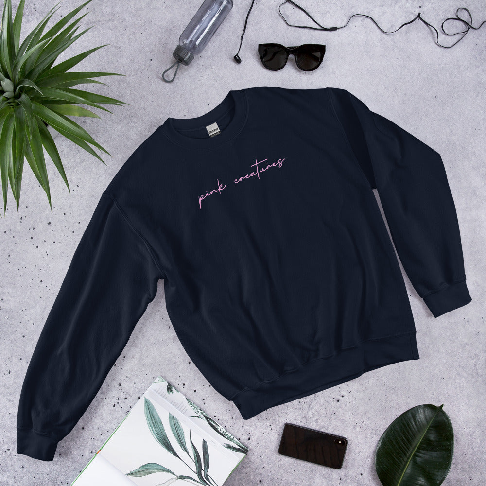 pink creatures title in pink crew neck