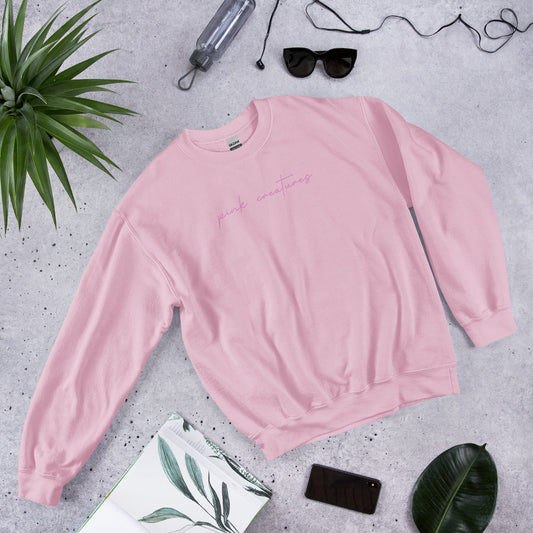 pink creatures title in pink crew neck